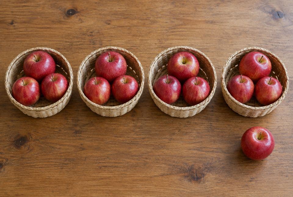Four small baskets each hold three red apples, and one apple sits by itself on the table.