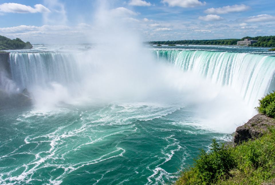 Horseshoe Falls at Niagara Falls, with water pouring over a curved edge and mist rising.