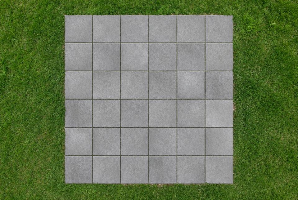 A square patio of grey concrete stones, 6 rows of 6, surrounded by green grass, seen from above.