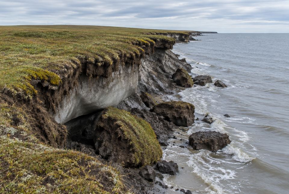 An Arctic tundra shoreline where chunks of eroding, permafrost-rich bluff have collapsed into the sea.