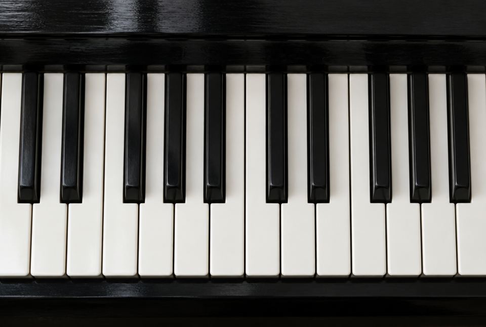 Top view of a piano keyboard showing white keys and black keys in alternating groups of two and three.